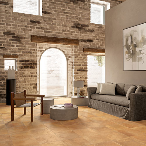 Ambiente living realizzato con pavimento e rivestimento variante Goldensun, collezione Home effetto cotto