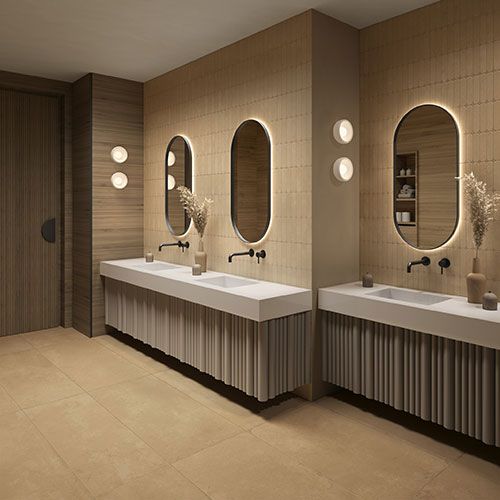 Locale bagni in ambiente pubblico, realizzato con pavimento e rivestimento Miso - Ochre, collezione Iro