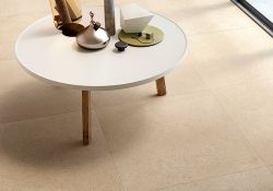 Scatto ravvicinato del pavimento della collezione Cover, con tavolino bianco ed alcuni arredi