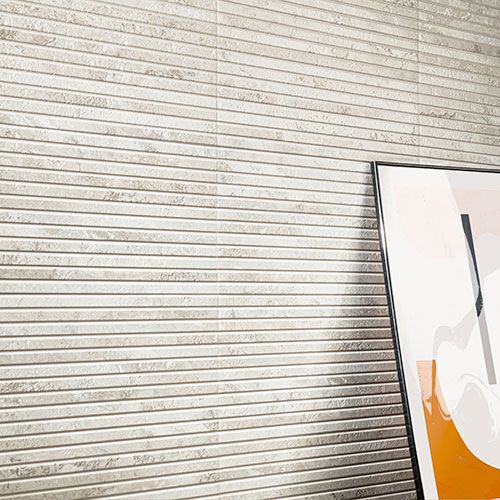 Immagine in primo piano del rivestimento di un living in un moderno appartamento, serie Bloom colore Grey