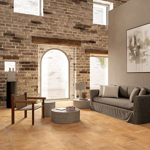 Ambiente living realizzato con pavimento e rivestimento variante Goldensun, collezione Home effetto cotto