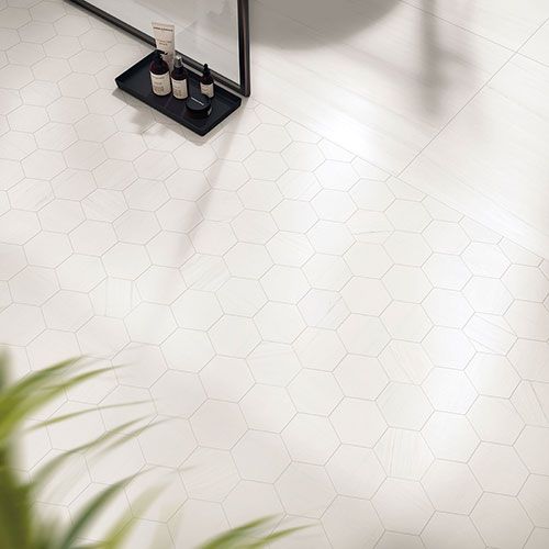 Immagine del pavimento serie Charme colore Biancospino, con alcuni oggetti posati sopra al pavimento realizzato con mosaico Esa in gres con effetto marmo bianco